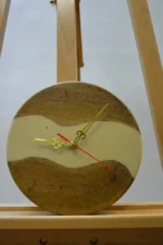 Tömör fa falióra epoxigyantával (23 cm), sötétebb fa bézs epoxigyanta folyóval és arany mutatókkal, állványon.