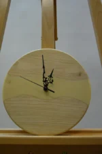 Tömör fa falióra epoxigyantával (23 cm) világos fából, bézs gyanta berakással és díszített fekete mutatókkal, állványon.