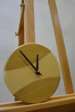 Tömör fa falióra epoxigyantával (23 cm) fából és bézs műgyantából, fekete mutatókkal, fa állványon állva.
