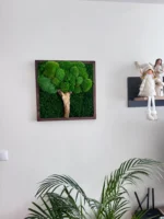 Négyzet alakú mohafa dekoráció sötét fakeretben, fehér falon.