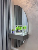 Zöld moha bonsai világító keretben szürke konzolasztalon.